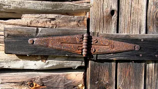 Gamle rustne hengsler på trebygg